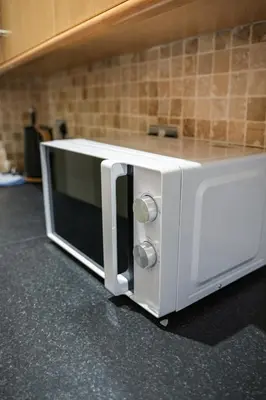a white microwave oven sitting on top of a counter at Neilston Gateaway in Paisley