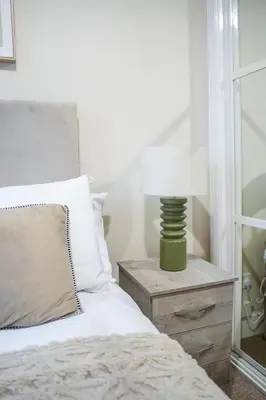 a bedroom with a bed and a lamp on a nightstand at Neilston Gateaway in Paisley