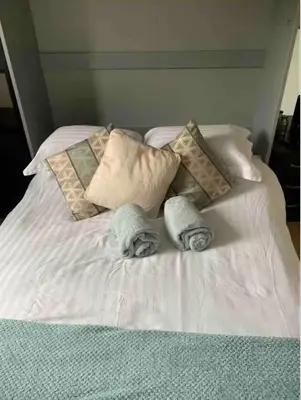 a white bed with pillows and towels on it at City Centre Double Room in Glasgow