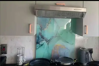 a kitchen with a stove with a painting on the wall at City Centre Double Room in Glasgow