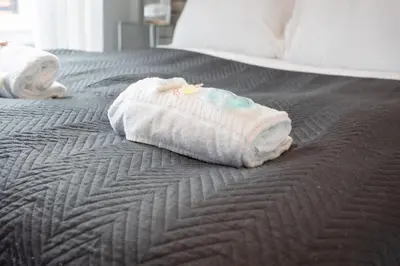 two towels are sitting on a bed at Central Renfrew 1BR Apt in Renfrew