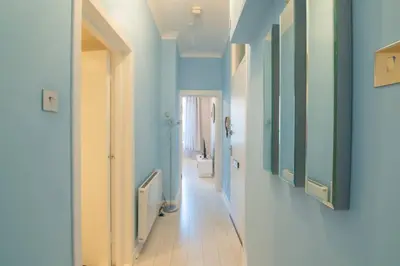 a hallway with blue walls and a hallway with a bathroom at Central Renfrew 1BR Apt in Renfrew