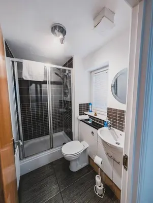 a bathroom with a toilet and a sink and a shower at Modern 2-Bed Near Braehead in Renfrew