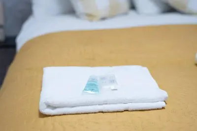a pile of white towels sitting on a bed at Stylish 2BR in Renfrew in Renfrew