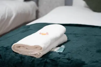 a white towel sitting on top of a bed at Stylish 2BR in Renfrew in Renfrew