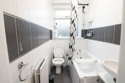a white bathroom with a toilet and a sink at Stylish 2BR in Renfrew in Renfrew
