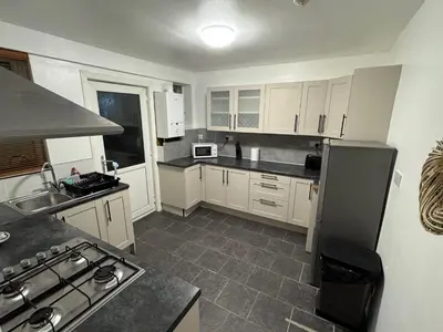 a kitchen with white cabinets and a stove top oven at Stylish 2BR in Renfrew in Renfrew