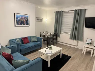 a living room with a blue couch and a table at Stylish 2BR in Renfrew in Renfrew