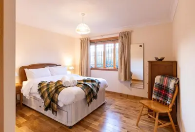 a bedroom with a bed and a window and a chair at Bright, spacious house in Edinburgh