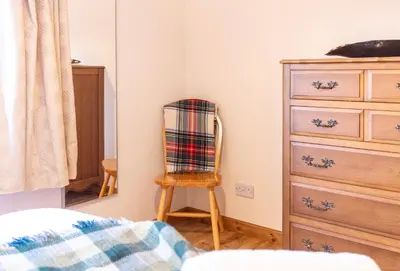a bedroom with a chair and a dresser at Bright, spacious house in Edinburgh