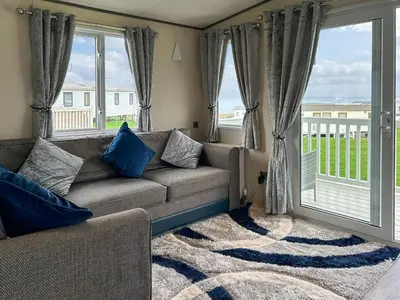 a living room with a couch and a large window at Ocean Bay View - Ukc7143 in Ayr