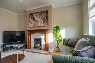 a living room with a couch and a fireplace at Castlehill House in Boʼness