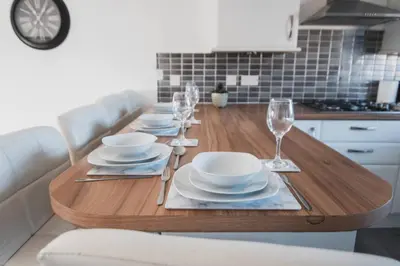 a dining room table with plates and wine glasses at Modern 3BR Flat with Parking in Renfrew