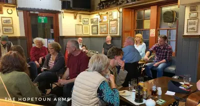 a group of people sitting in a room at The Hopetoun Arms Hotel in Leadhills