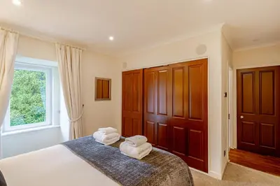 a bedroom with two towels on a bed with a window at Spacious Gleneagles Apartment