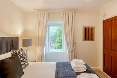 a bedroom with a bed and a window at Spacious Gleneagles Apartment