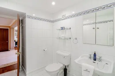 a white bathroom with a toilet and a sink at Spacious Gleneagles Apartment