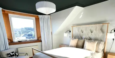 a bedroom with a white bed and a window at Carmona Bank in Dunoon