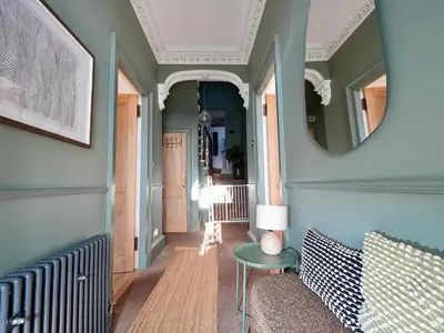 a hallway with a table and a mirror at Carmona Bank in Dunoon