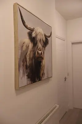 a painting of a bull hanging on a wall at Elegant 3BR Apt at Haymarket in Edinburgh