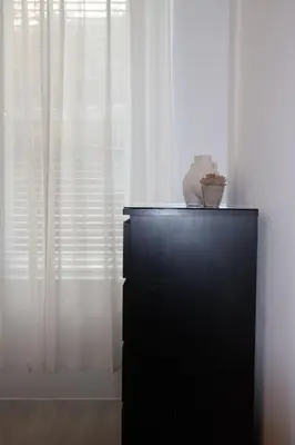 a vase on top of a dresser in front of a window at Elegant 3BR Apt at Haymarket in Edinburgh