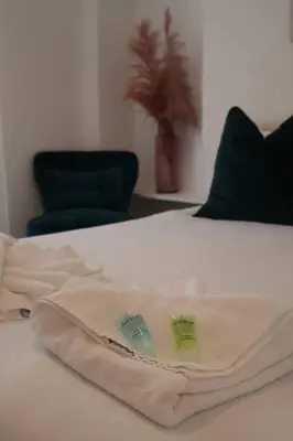 a white bed with two towels on top of it at Elegant 3BR Apt at Haymarket in Edinburgh