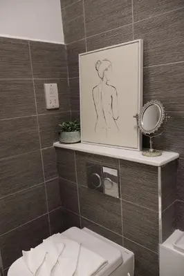 a bathroom with a drawing of a woman on a wall at Elegant 3BR Apt at Haymarket in Edinburgh