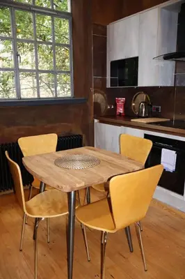 a wooden table and chairs in a kitchen at Stockbridge 1BR with Parking in Edinburgh