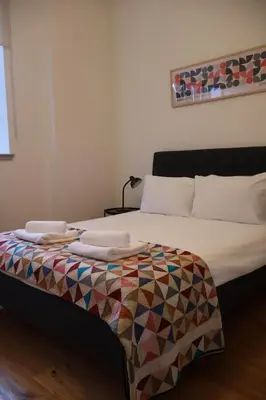 a bed with white sheets and towels on it at Stockbridge 1BR with Parking in Edinburgh