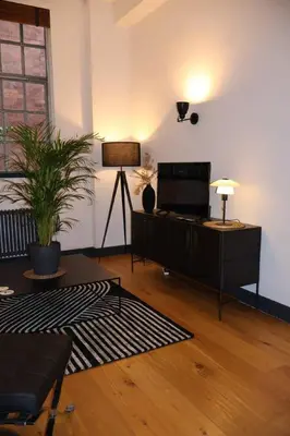 a living room with a couch and a lamp at Stockbridge 1BR with Parking in Edinburgh