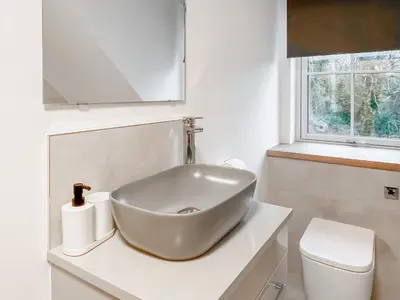 a white bathroom with a sink and a toilet at Eriska View in Port Appin