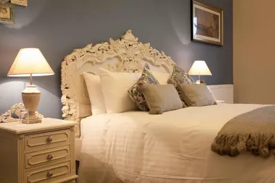 a bedroom with a large white bed with pillows at Inglewood House and Spa in Alloa
