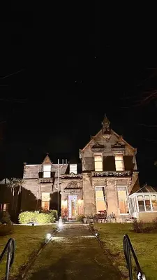 an old house at night with its lights on at West Coates Mansion in Edinburgh