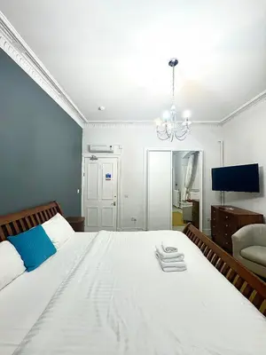 a bedroom with a large white bed and a chandelier at West Coates Mansion in Edinburgh