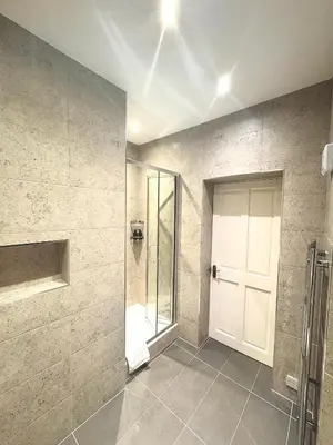 a bathroom with a shower and a white door at West Coates Mansion in Edinburgh