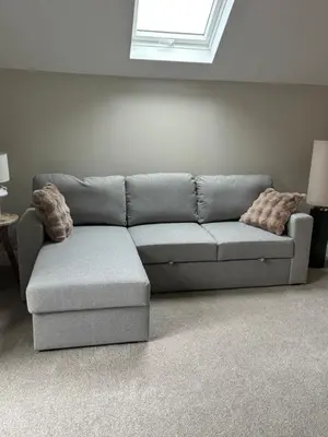 a grey couch with two pillows in a living room at Craigievar Cottage Skelmorlie in Skelmorlie