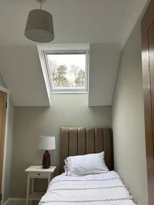 a bedroom with a bed with a window above it at Craigievar Cottage Skelmorlie in Skelmorlie