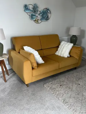 a brown couch sitting in a living room with pillows at Craigievar Cottage Skelmorlie in Skelmorlie