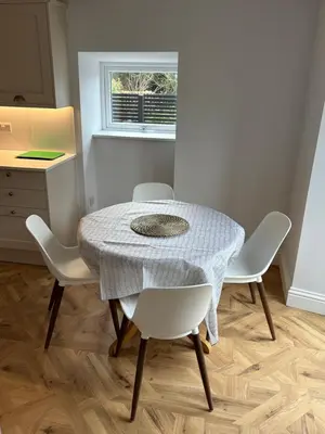 a table and chairs in a room with a window at Craigievar Cottage Skelmorlie in Skelmorlie