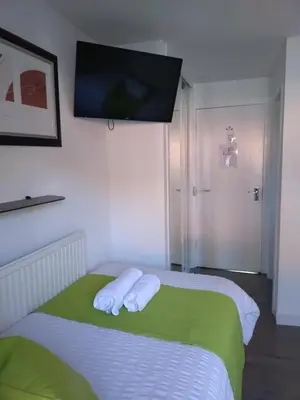 a bedroom with a bed with two white towels on it at Anchorage Accommodation in Balloch