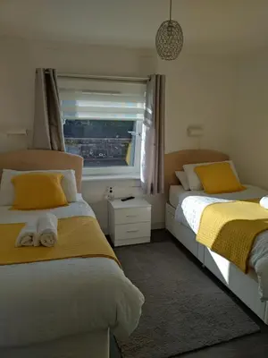 a bedroom with two beds and a window at Anchorage Accommodation in Balloch
