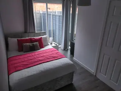 a bedroom with a bed with red sheets and a window at Anchorage Accommodation in Balloch