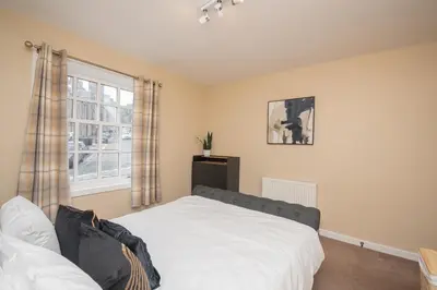 a bedroom with a white bed and a window at Bow Apartment in Stirling