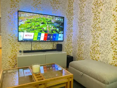 a living room with a couch and a flat screen tv at Paisley Central Apartment in Paisley