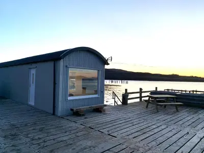 a small shack on a dock next to a table at Salen Pier Haven in Salen