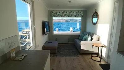 a living room with a couch and a large window at Salen Pier Haven in Salen