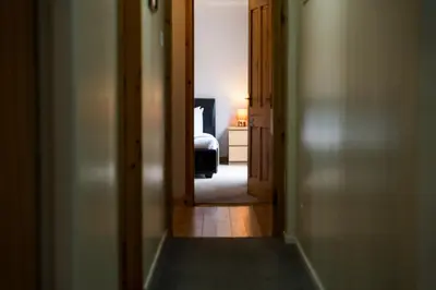 a hallway with a door open to a bedroom with a bed at Westwood in Oban