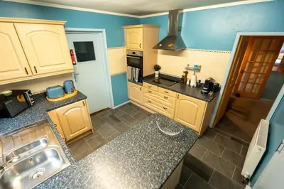 a small kitchen with wooden cabinets and a sink at Westwood in Oban