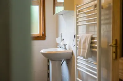 a white bathroom with a sink and a window at Westwood in Oban