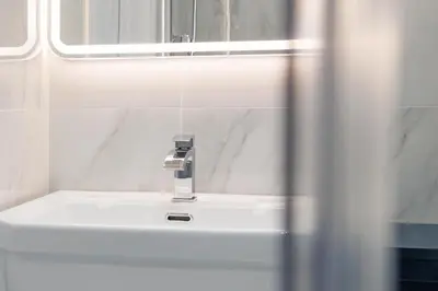 a bathroom with a white sink and a mirror at Savoy 5 in Ayr